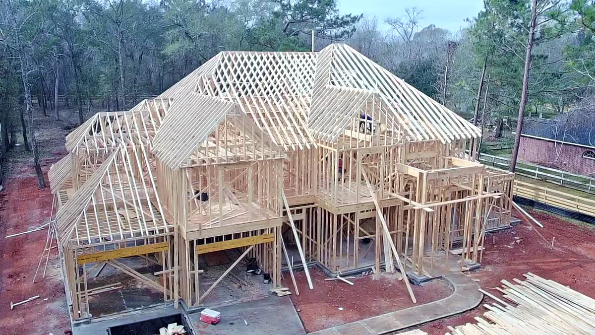 Aerial view of a home framed with roof trusses in place